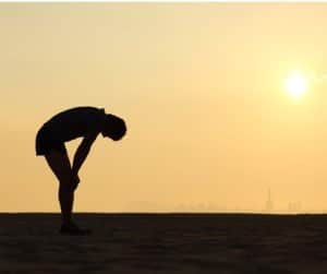 person with hands on their knees