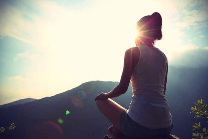 woman practicing yoga on mountain