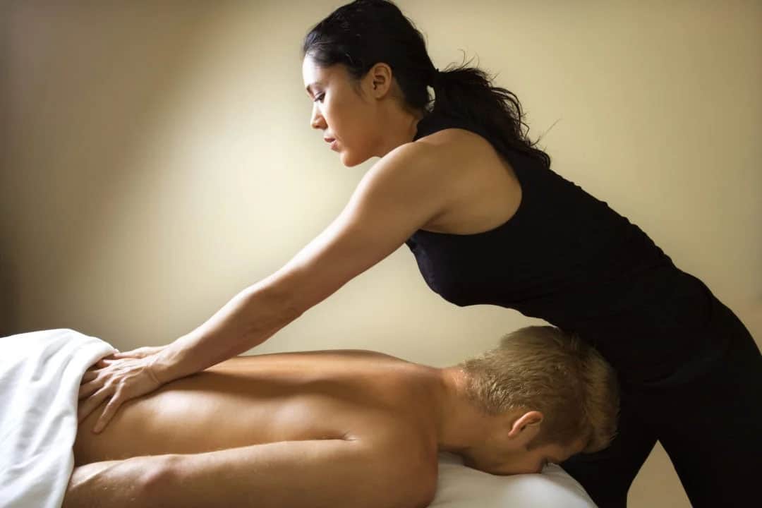 massage therapist during session with man on table