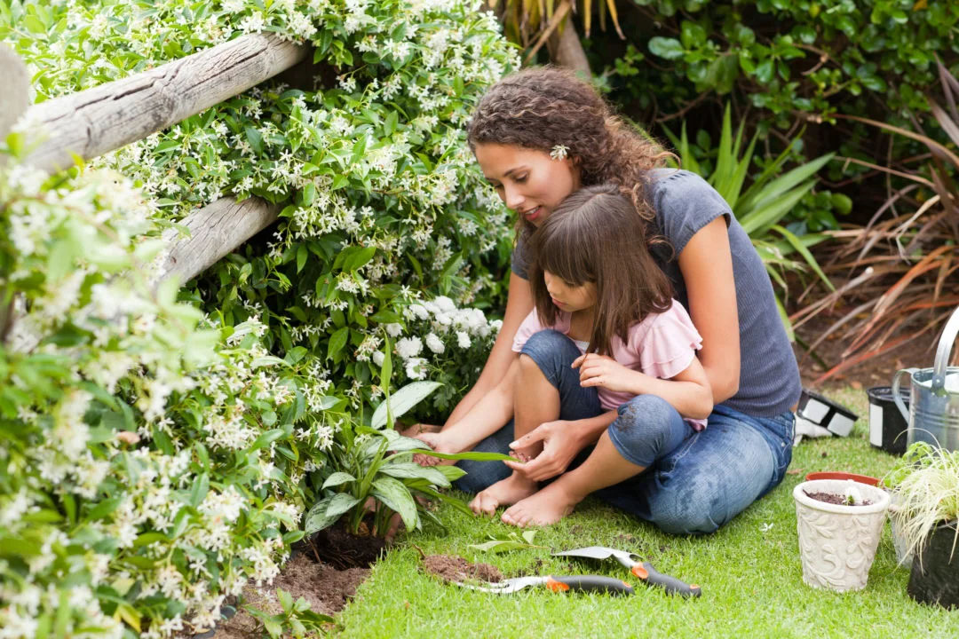mom gardening with her daughter in lap