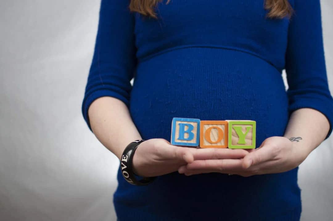 Mom holding blocks that spell out BOY